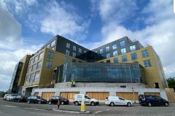 Big modern building, on road with cars