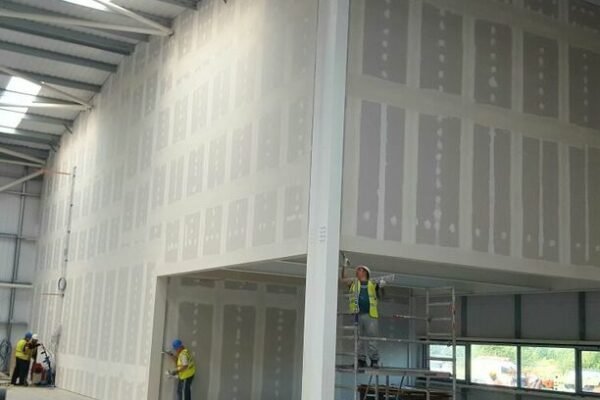 Men in hi-vis plastering interior walls