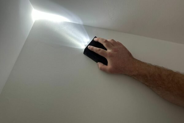 Man doing quality checks on a ceiling with a leveller